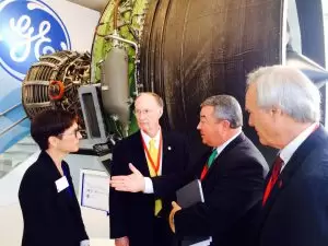 Commerce Secretary Greg Canfield speaks to GE Aviation executive Colleen Athans as Governor Robert Bentley and Chief of Staff Seth Hammett look on prior to company's project announcement to bring additive manufacturing to its Auburn facility. July 15, 2014