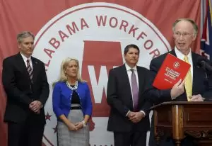 Gov. Robert Bentley holds a report prepared by members of the Alabama Workforce Council containing bold recommendations to advance Alabama's workforce development efforts at the state Capitol, Wednesday, Feb. 4, 2015